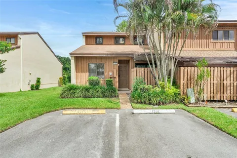 a front view of a house with a yard and potted plants