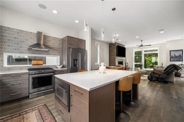 a kitchen with stainless steel appliances kitchen island granite countertop a stove and a sink