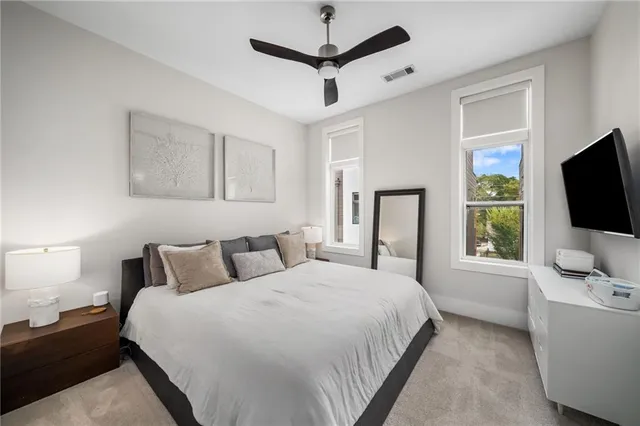 a bedroom with a bed flat screen tv and a window