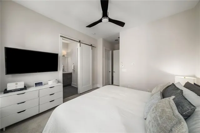 a bedroom with a bed and a flat tv screen on wall