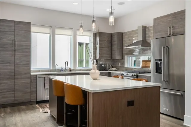 a kitchen with stainless steel appliances granite countertop a sink refrigerator and cabinets