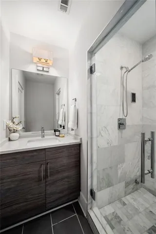 a bathroom with a shower sink vanity and mirror