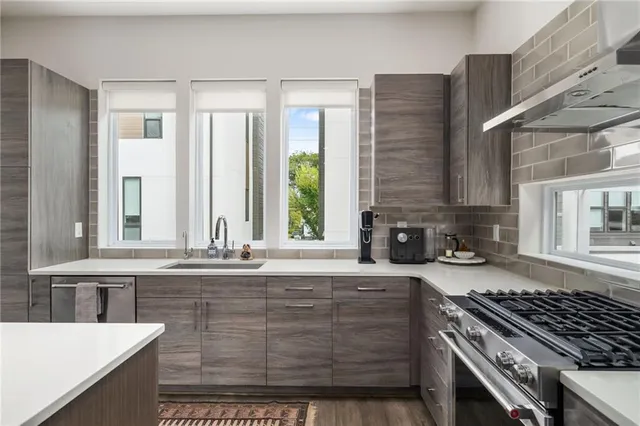 a kitchen with granite countertop a stove a sink and wooden cabinets