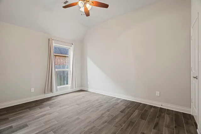 a view of an empty room with wooden floor