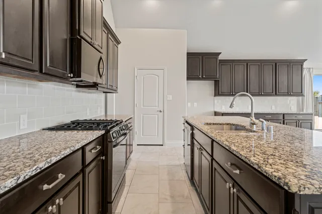 a kitchen with stainless steel appliances granite countertop a stove and a sink