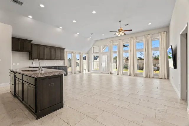 a large white kitchen with a large counter top appliances and cabinets