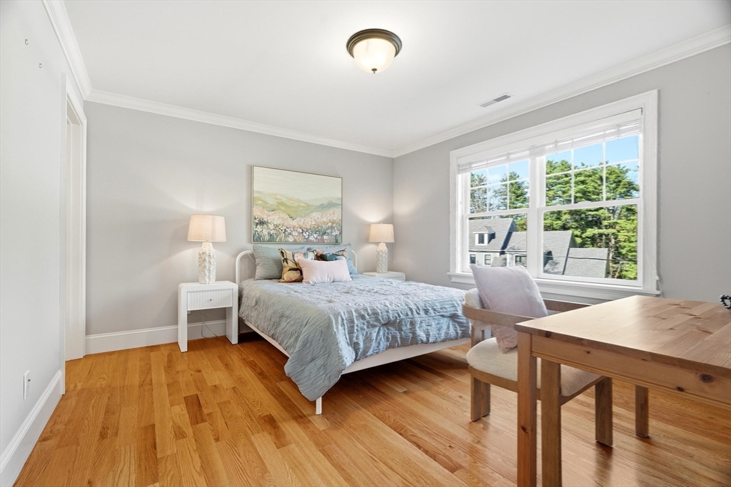 6 Flintlock Road Lexington, MA 02420 - Photo 26 of 39 a bedroom with a bed and wooden floor