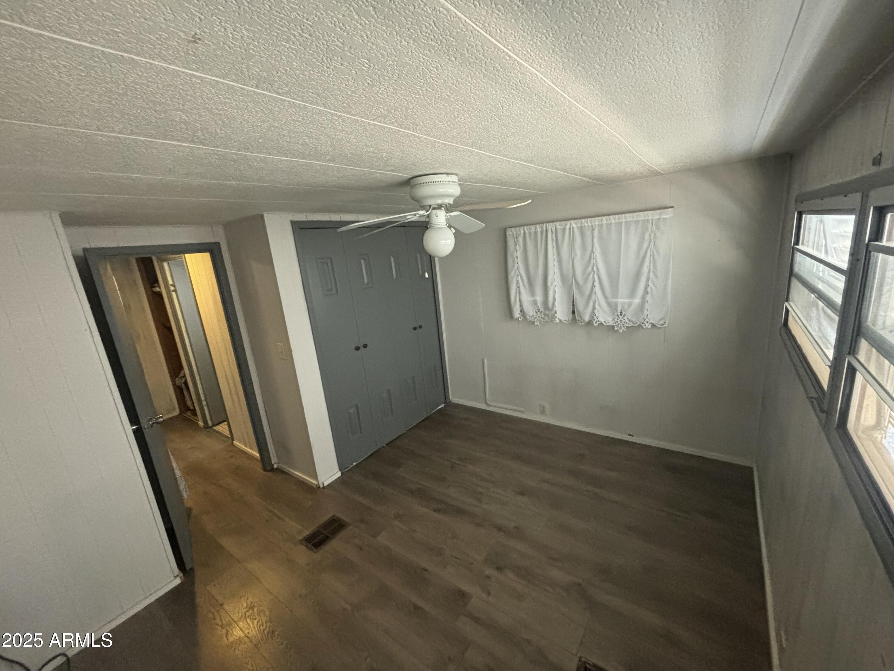 269 North Winchester Road, Unit 7 Apache Junction, AZ 85119 - Photo 14 of 26 an empty room with wooden floor and windows