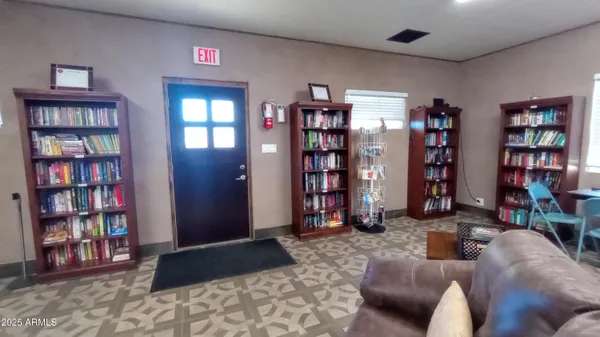 a living room with furniture a bookshelf and a window