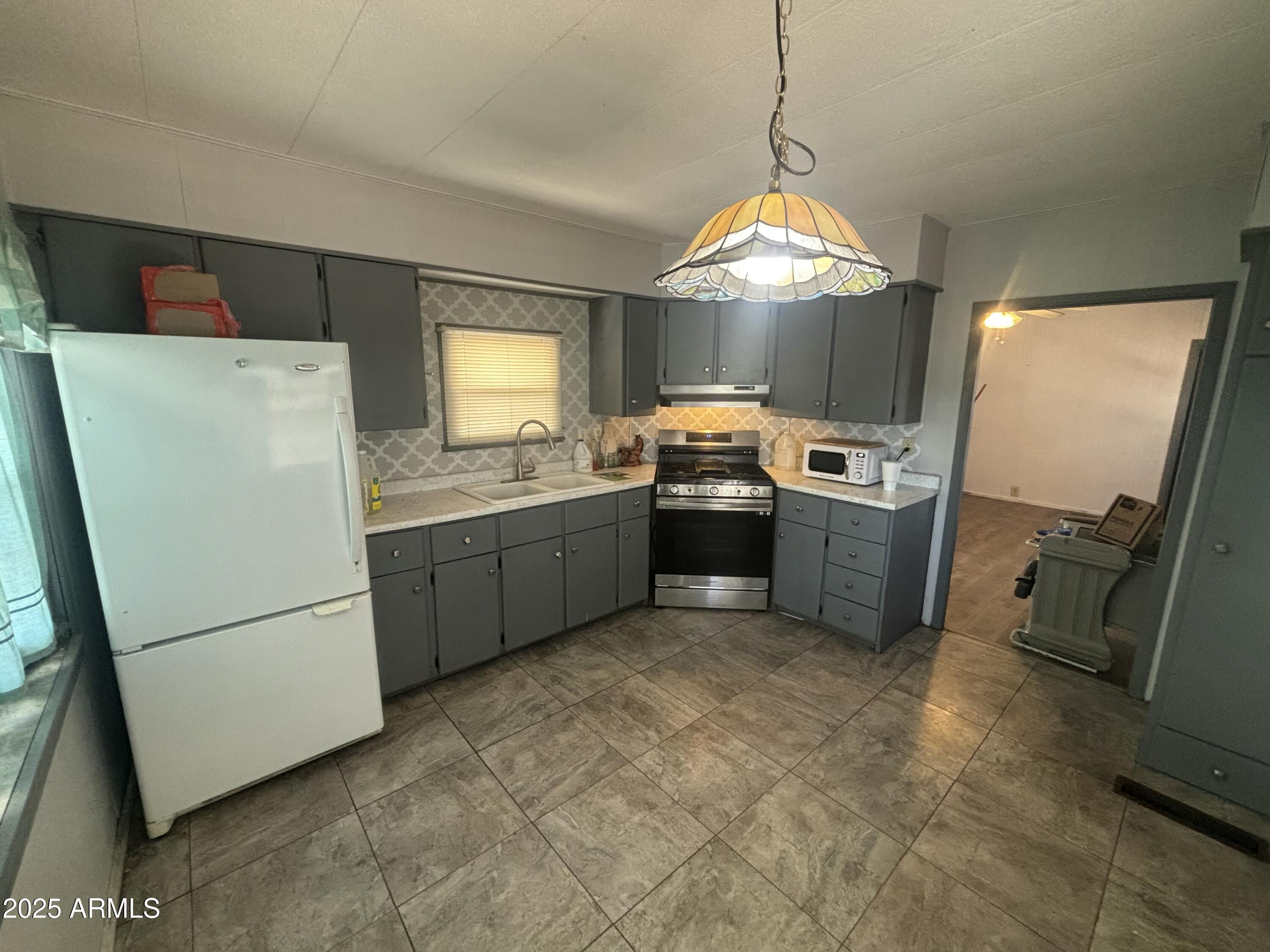 269 North Winchester Road, Unit 7 Apache Junction, AZ 85119 - Photo 9 of 26 a kitchen with stainless steel appliances granite countertop a refrigerator a sink a stove a washer dryer and a refrigerator