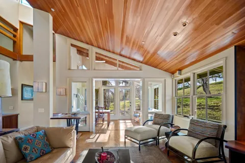 a living room with furniture and floor to ceiling windows