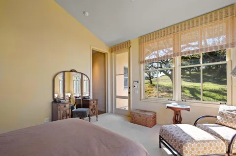 a bedroom with a bed and a large window