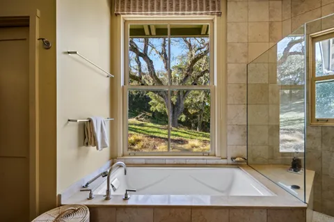 a view of bathroom with tub and window