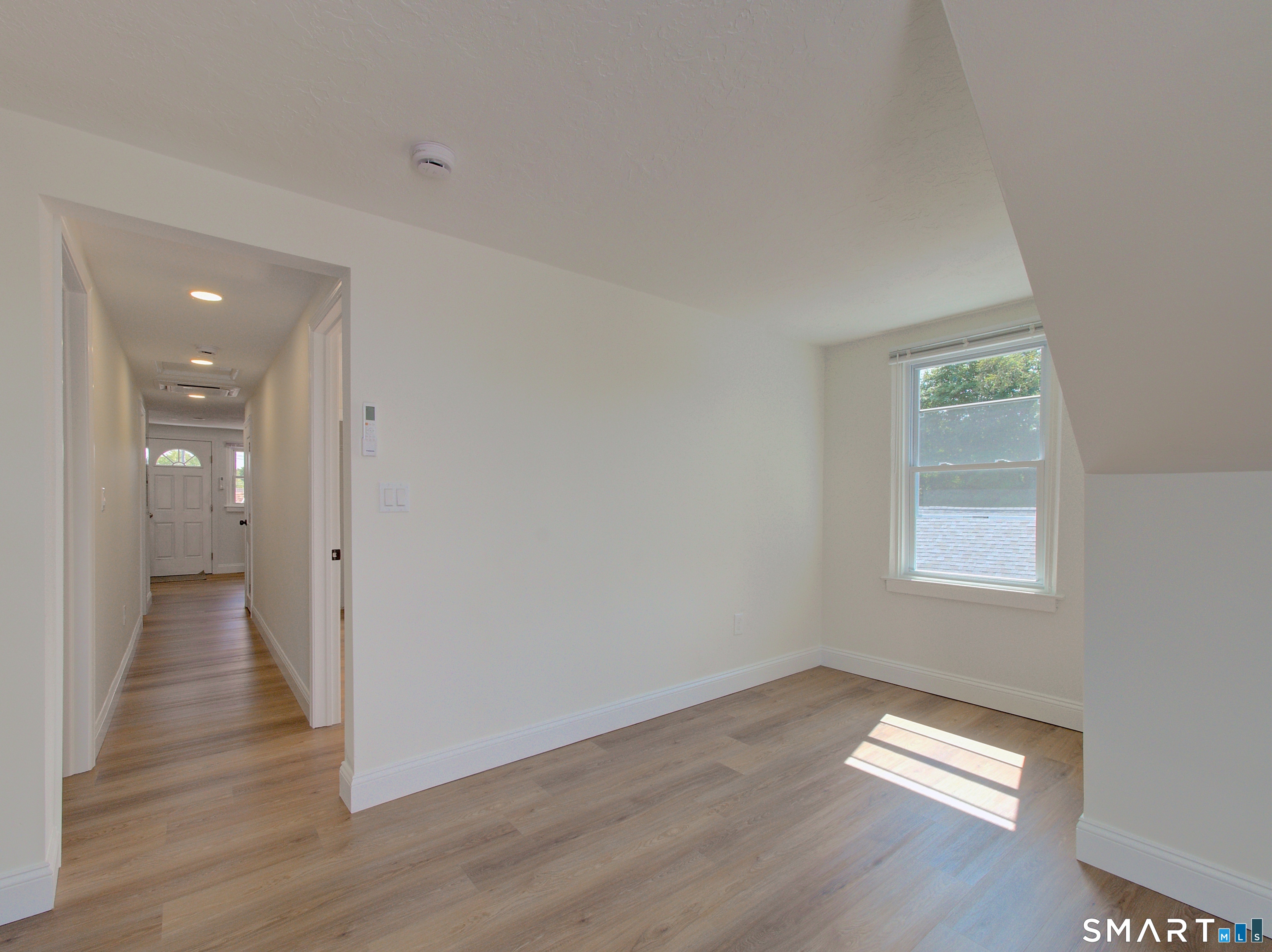 16 Benham Road, Unit D Groton, CT 06340 - Photo 14 of 15 an empty room with wooden floor and windows