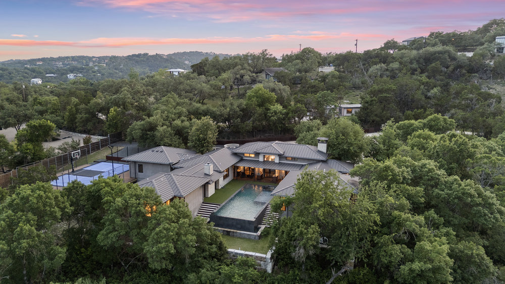 1905 Paisano Road Austin, TX 78746 - Photo 39 of 40 An aerial panorama showcases this extensive property featuring a sparkling pool, sport court, and serene natural surroundings.
