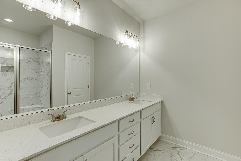 763 Woods Chapel Road Sugar Hill, GA 30518 - Photo 29 of 67 a bathroom with double sink and a mirror