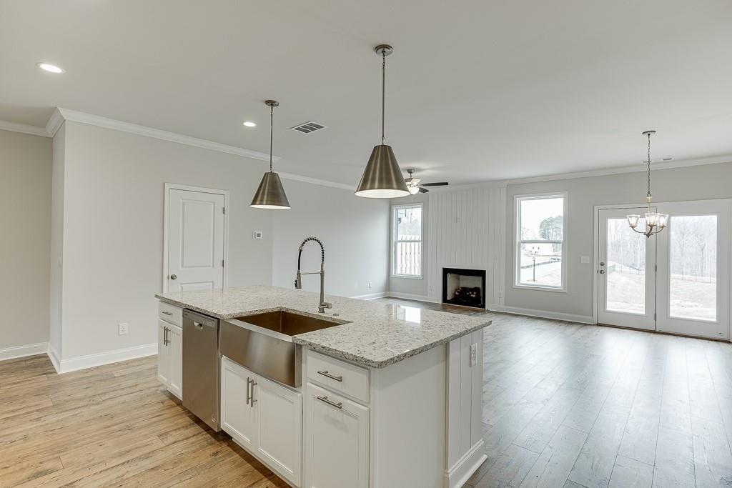 763 Woods Chapel Road Sugar Hill, GA 30518 - Photo 9 of 67 a kitchen with stainless steel appliances granite countertop a sink a microwave a stove and a wooden floors