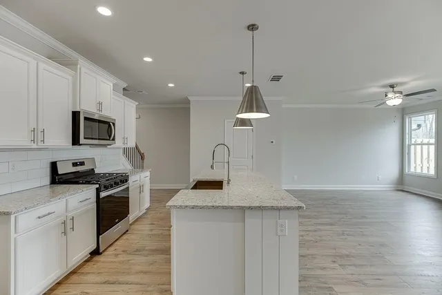 a view of kitchen with refrigerator and ceiling fan