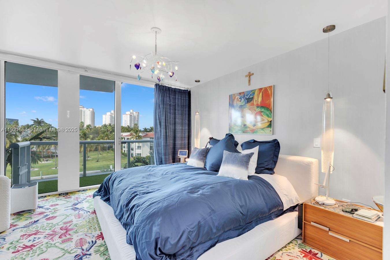 3131 Northeast 188th Street, Unit 2301 Aventura, FL 33180 - Photo 39 of 73 a bedroom with a bed and a chandelier