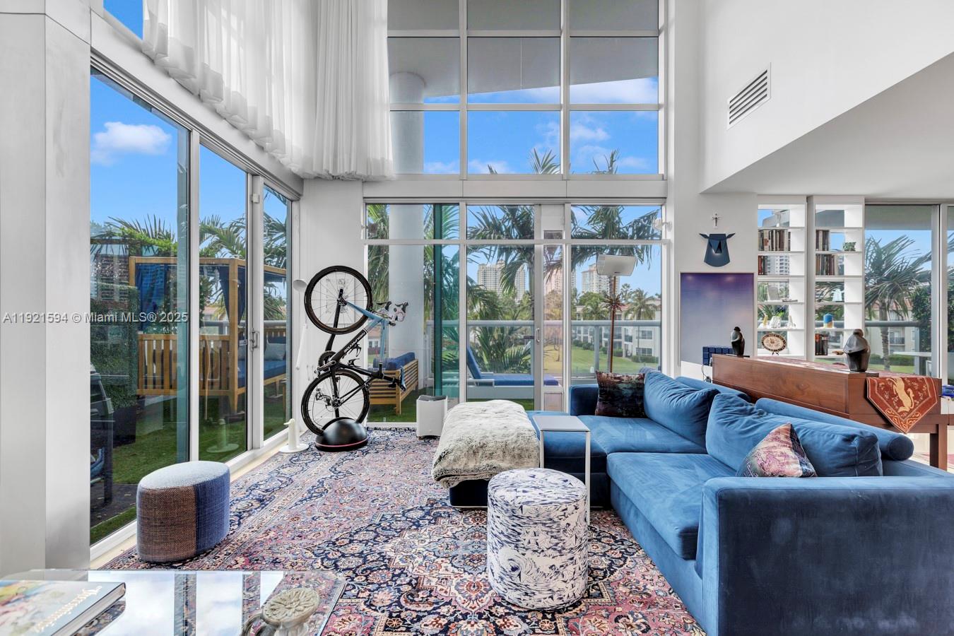 3131 Northeast 188th Street, Unit 2301 Aventura, FL 33180 - Photo 4 of 73 a living room with furniture two windows and a flat screen tv