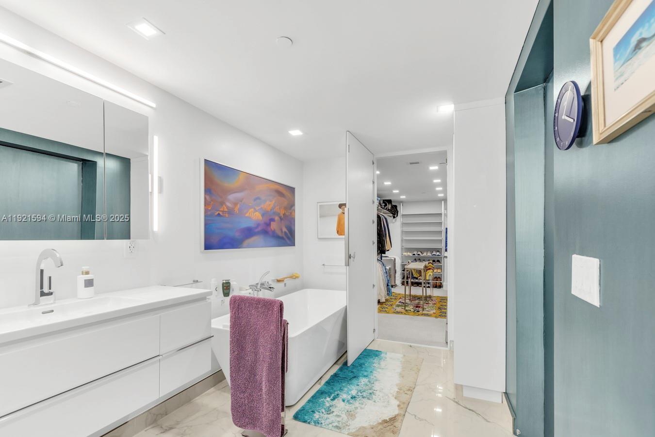 3131 Northeast 188th Street, Unit 2301 Aventura, FL 33180 - Photo 52 of 73 a bathroom with a tub sink and mirror