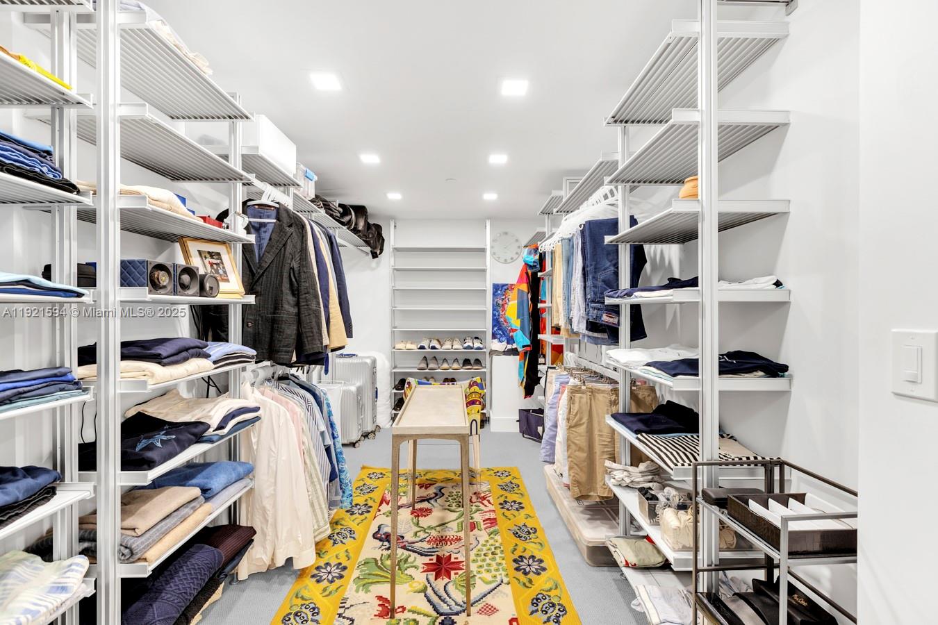 3131 Northeast 188th Street, Unit 2301 Aventura, FL 33180 - Photo 53 of 73 a view of a walk in closet with clothes and shoes