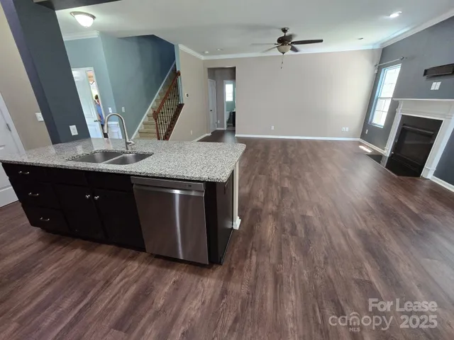 an empty room with wooden floor and staircase