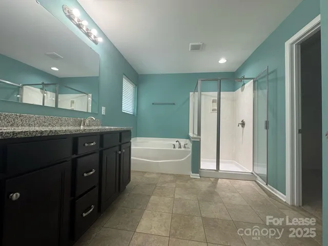 a spacious bathroom with a granite countertop sink a toilet and shower