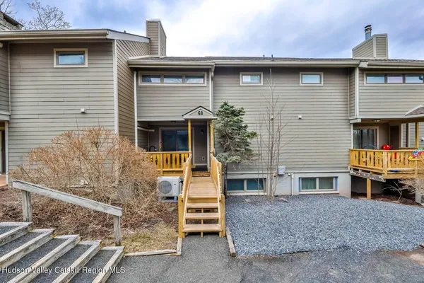 a living room with couches and a dining table with kitchen view