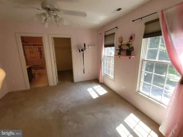 a view of empty room with windows and wardrobe