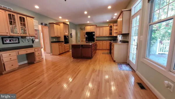 a view of kitchen with stainless steel appliances refrigerator wooden floor and outdoor kitchen