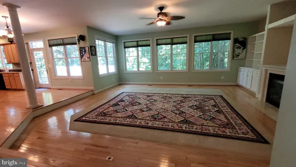 a view of a livingroom with wooden floor and a fireplace