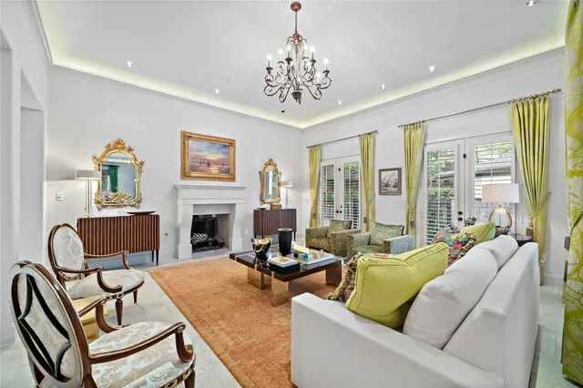 a living room with furniture a chandelier and a fireplace