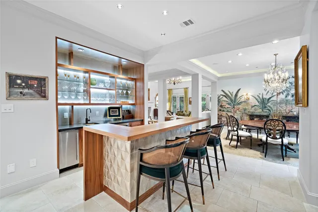 a kitchen with stainless steel appliances granite countertop table chairs and a refrigerator
