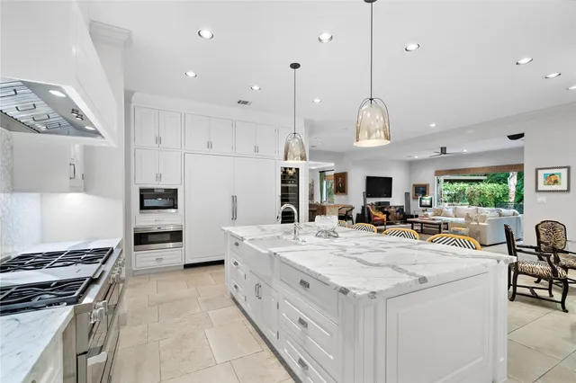 a large kitchen with stainless steel appliances granite countertop a stove and a cabinets