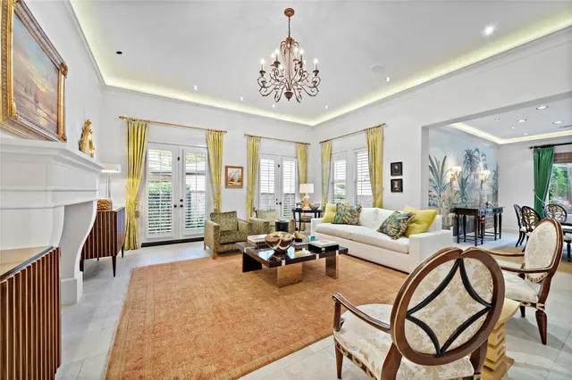 a living room with furniture a chandelier and a dining table