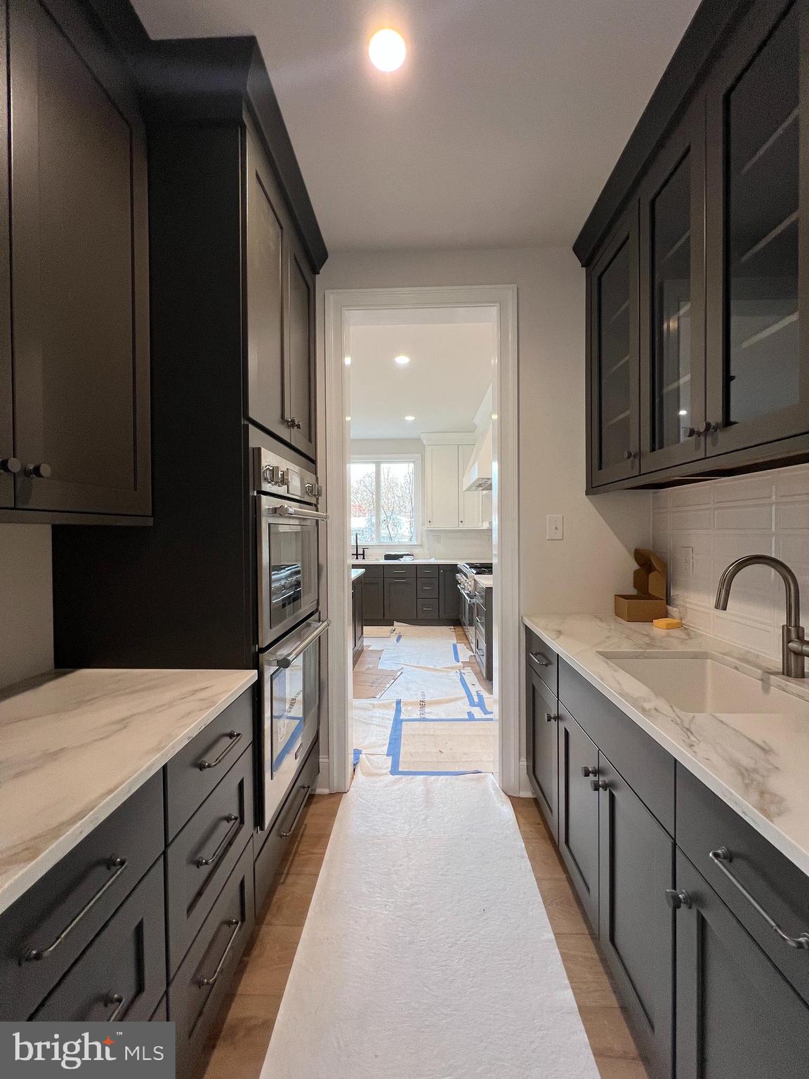 340 Hidden River Road Penn Valley, PA 19072 - Photo 28 of 57 a large kitchen with granite countertop a sink and dishwasher a stove top oven with wooden floor