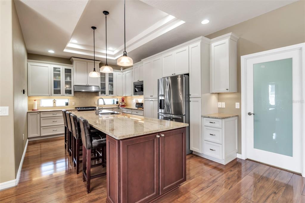 730 Old Quarry Road Bradenton, FL 34212 - Photo 20 of 65 a kitchen with stainless steel appliances a dining table chairs refrigerator and cabinets