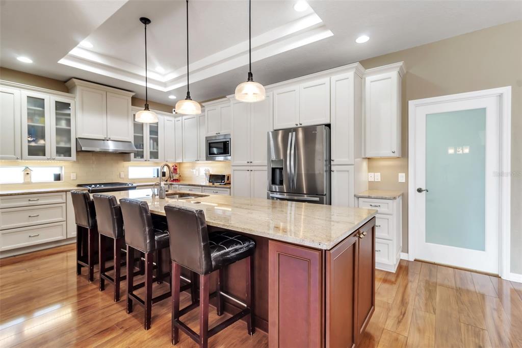 730 Old Quarry Road Bradenton, FL 34212 - Photo 21 of 65 a kitchen with stainless steel appliances a dining table chairs refrigerator and microwave