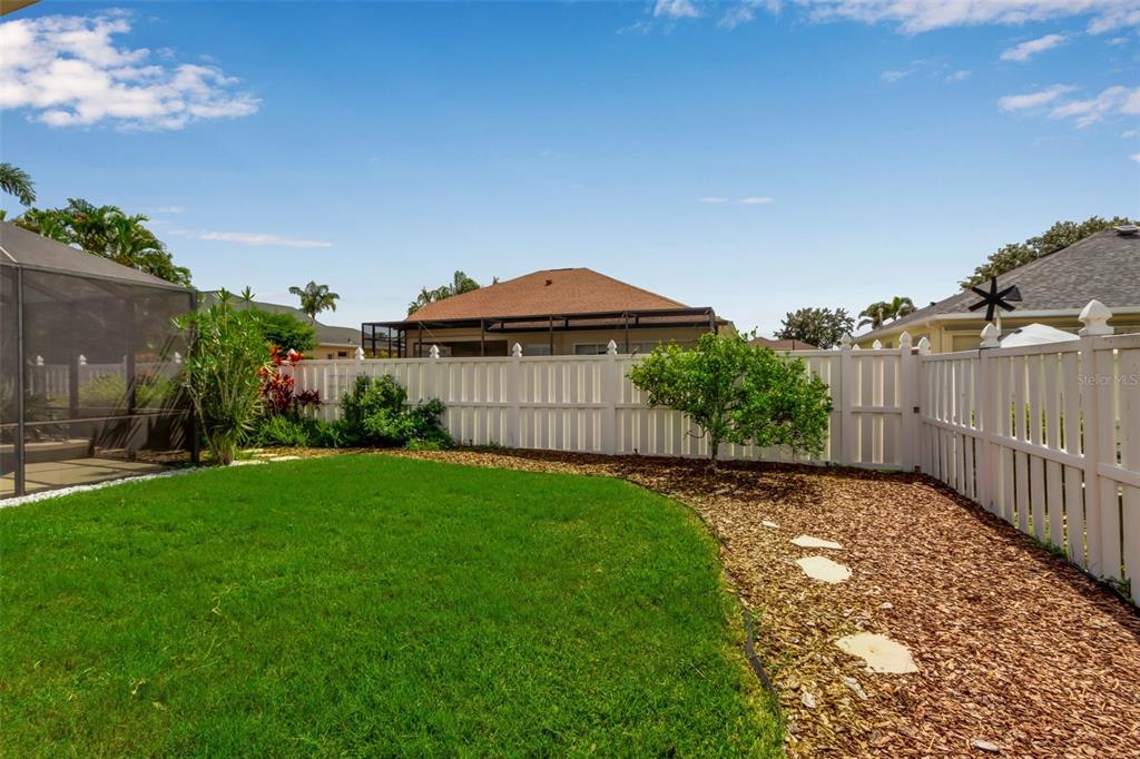 730 Old Quarry Road Bradenton, FL 34212 - Photo 62 of 65 a view of a back yard with flower plants and wooden fence