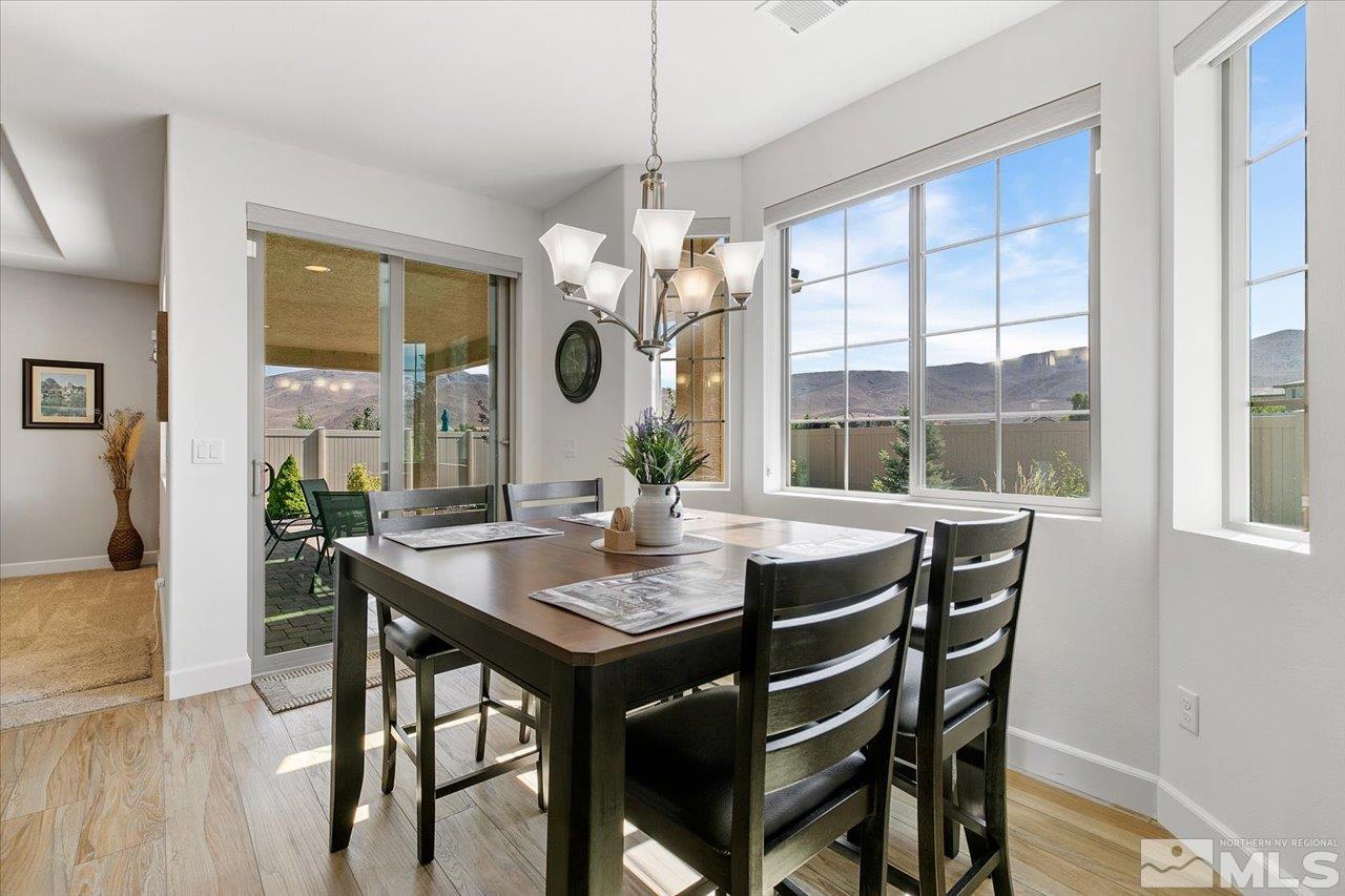 9934 Autumn Sage Drive Reno, NV 89521 - Photo 11 of 39 a dining room with wooden floor a chandelier a wooden table and chairs