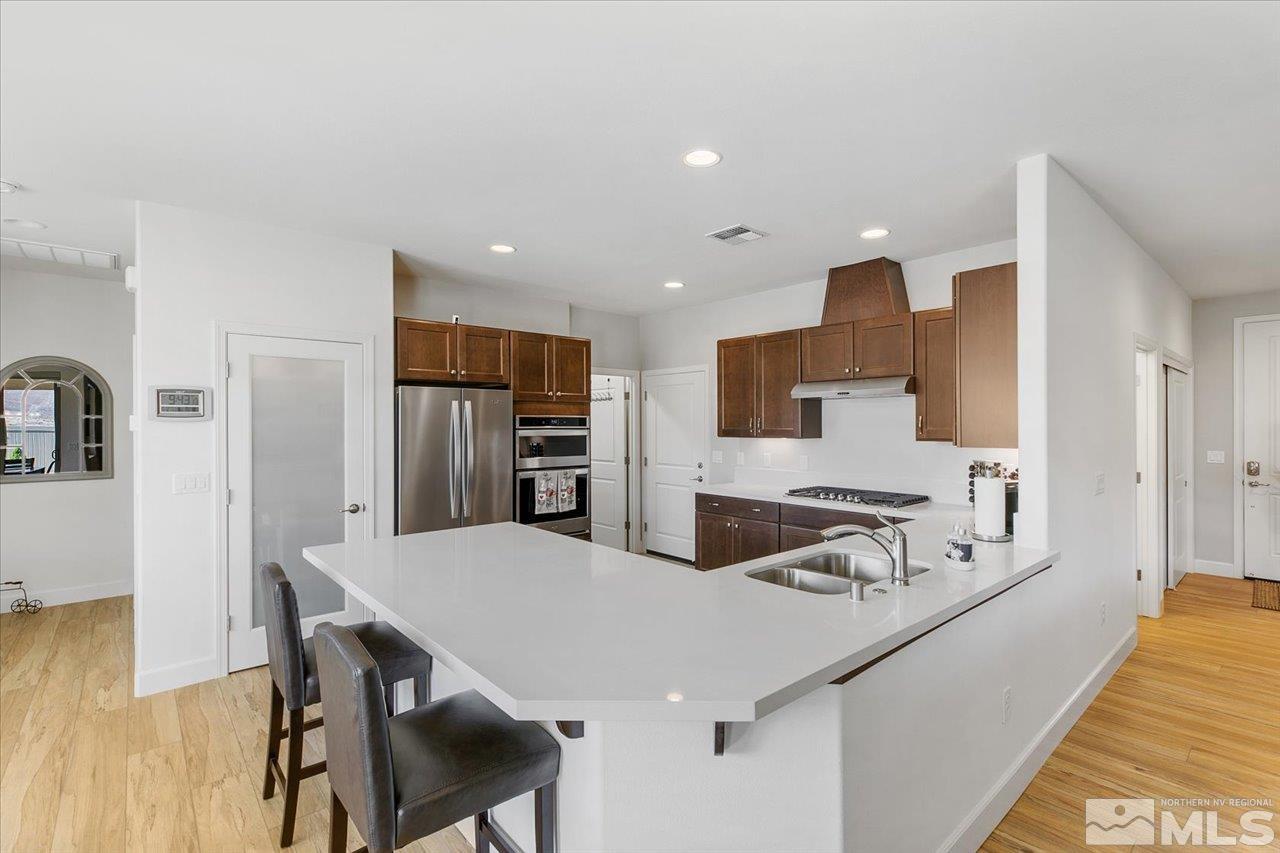 9934 Autumn Sage Drive Reno, NV 89521 - Photo 12 of 39 a kitchen with stainless steel appliances kitchen island granite countertop a sink and cabinets