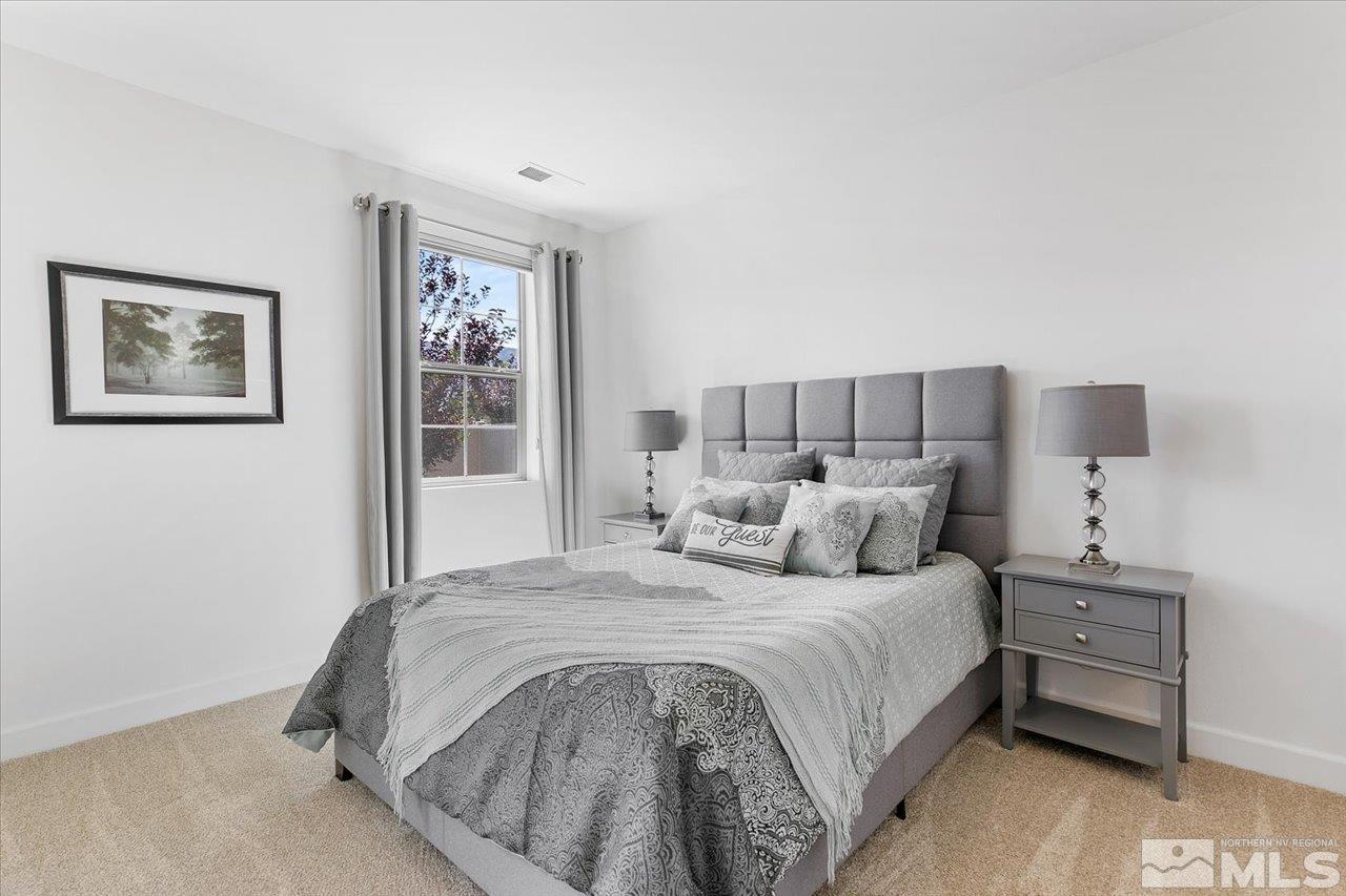 9934 Autumn Sage Drive Reno, NV 89521 - Photo 17 of 39 a bedroom with a large bed and lamp
