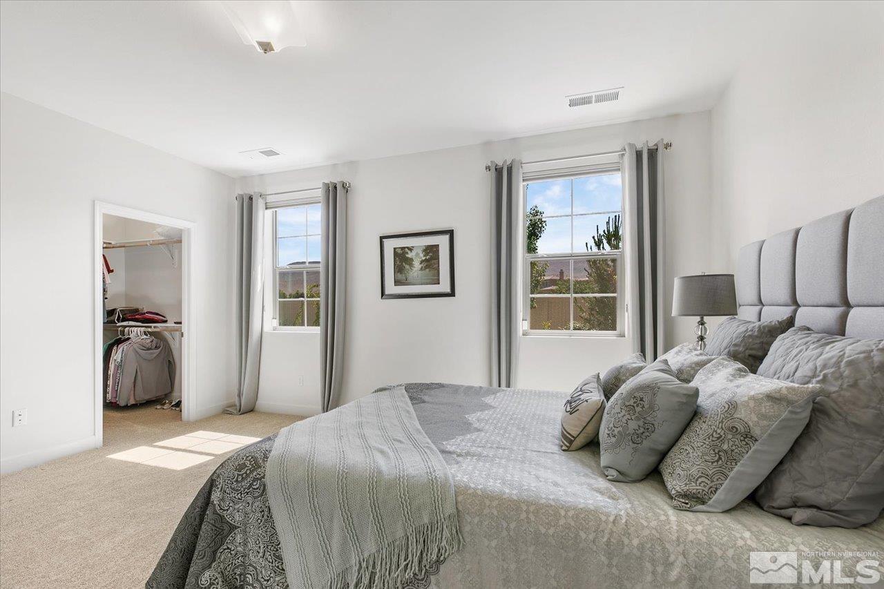 9934 Autumn Sage Drive Reno, NV 89521 - Photo 19 of 39 a bedroom with a large bed and a large mirror