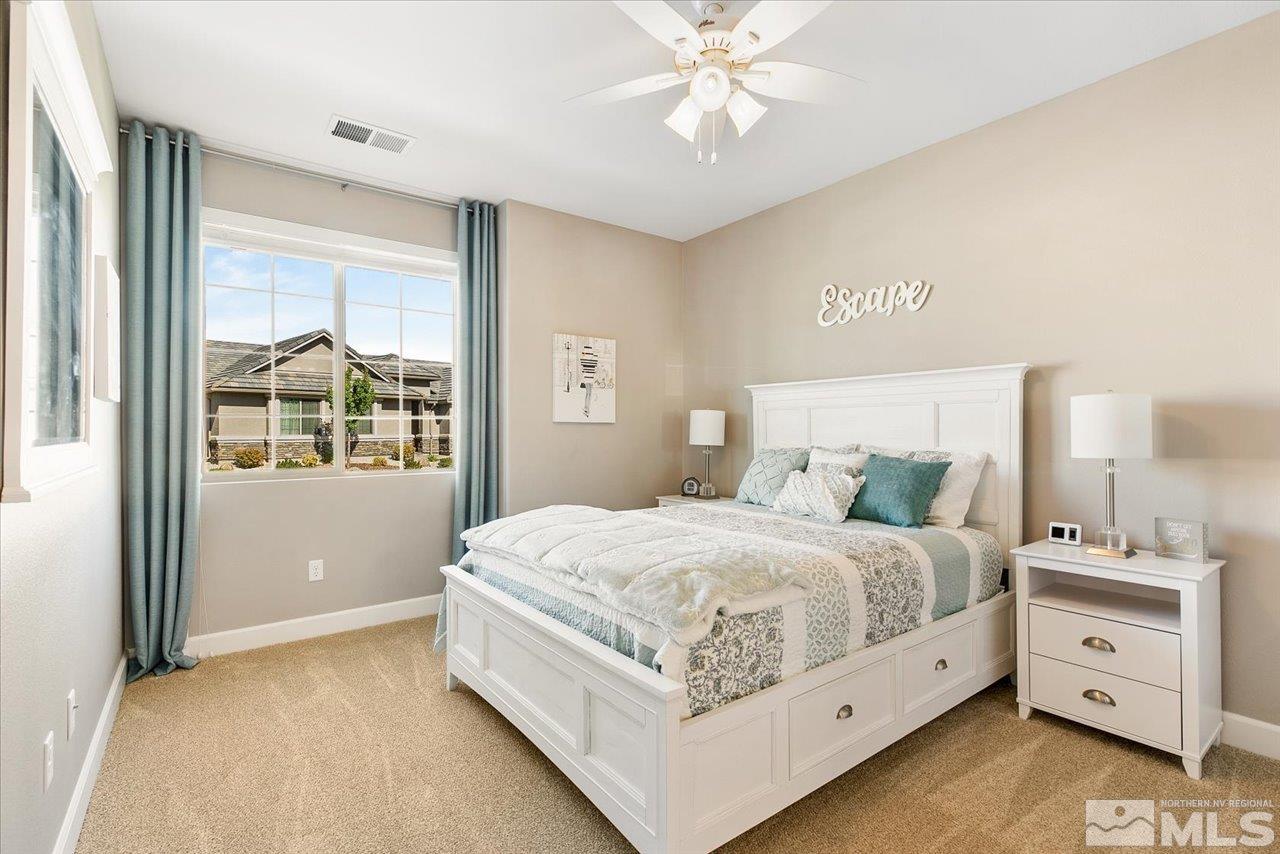 9934 Autumn Sage Drive Reno, NV 89521 - Photo 27 of 39 a bedroom with a large bed and a chandelier