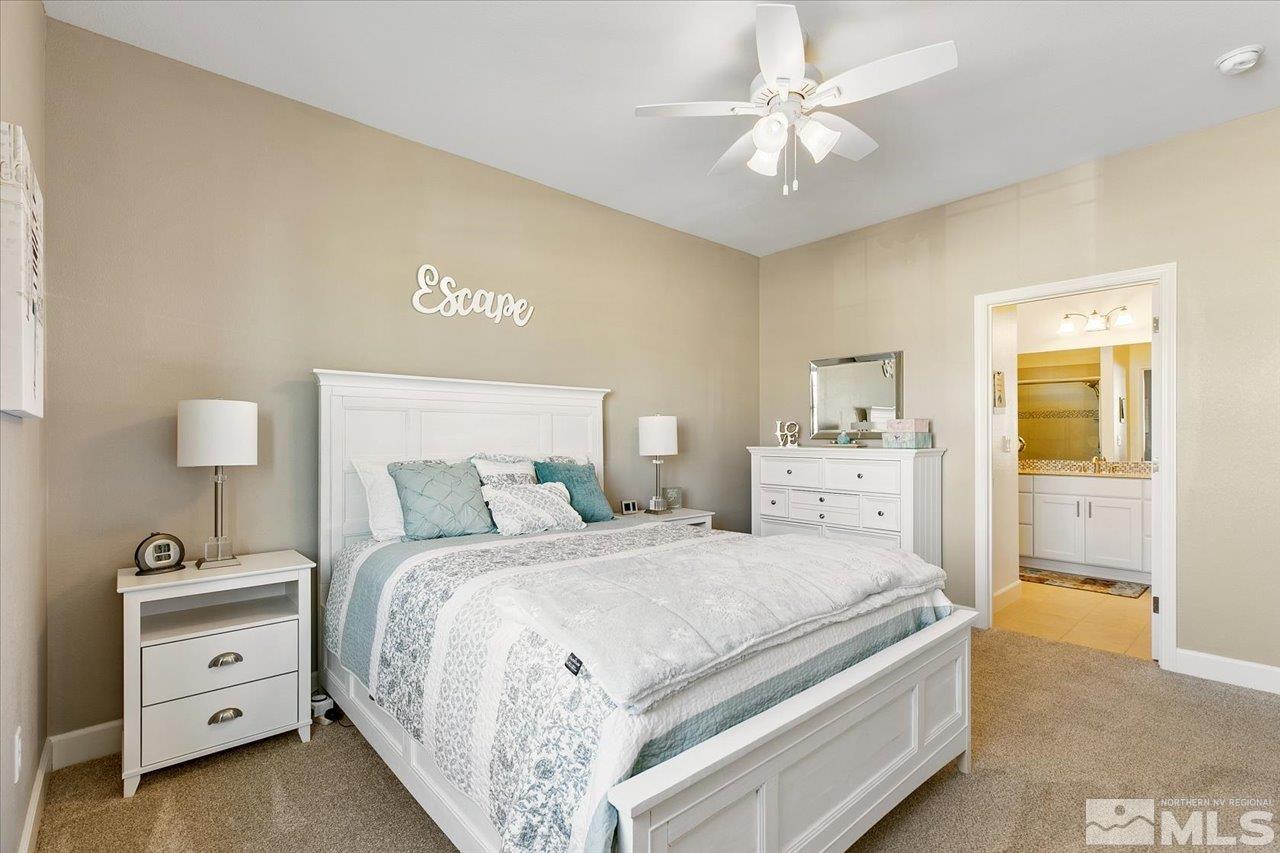 9934 Autumn Sage Drive Reno, NV 89521 - Photo 28 of 39 a spacious bedroom with a bed and a chandelier