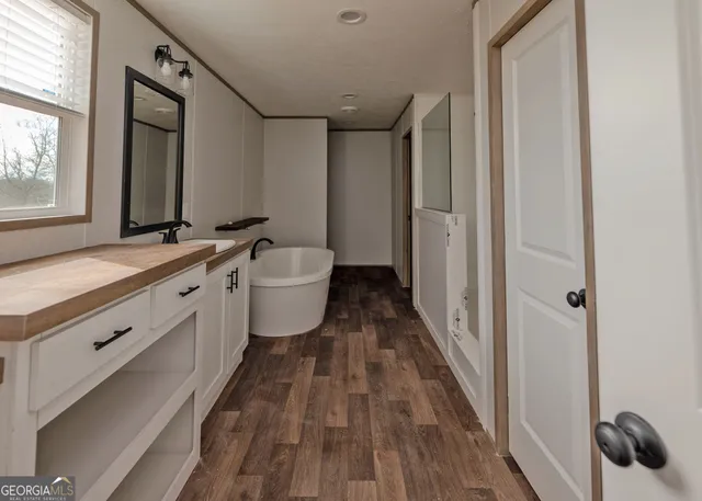 a spacious bathroom with a double vanity sink a mirror and a shower