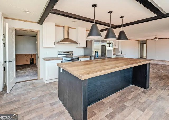a kitchen with a stove and a wooden floor