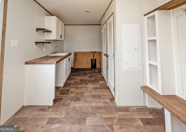 a view of a kitchen with wooden floor and a sink