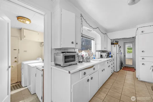 a kitchen with white cabinets and appliances